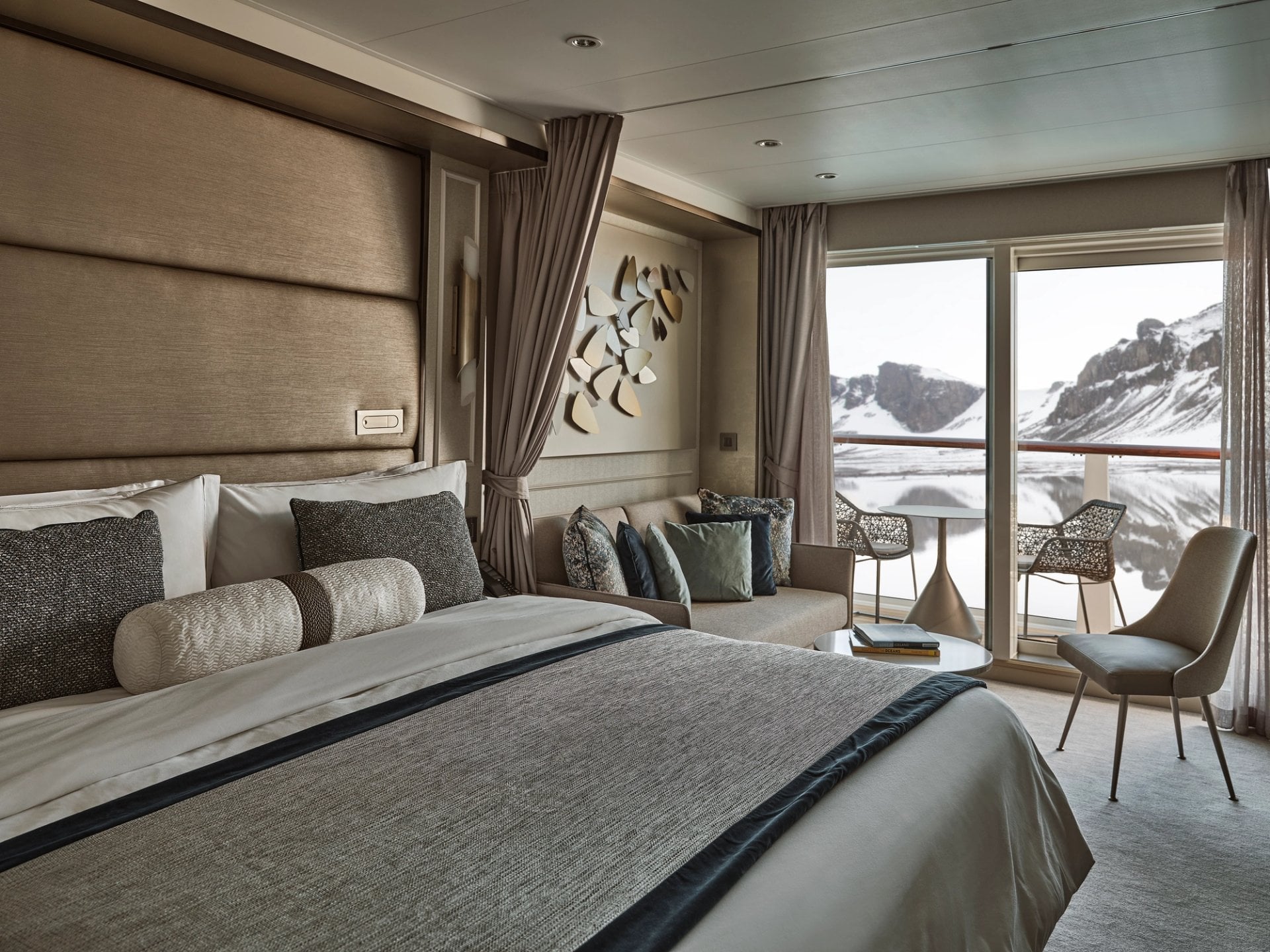 Silversea expedition butler presenting champagne and gourmet hors d'oeuvres inside a luxury veranda suite in Antarctica