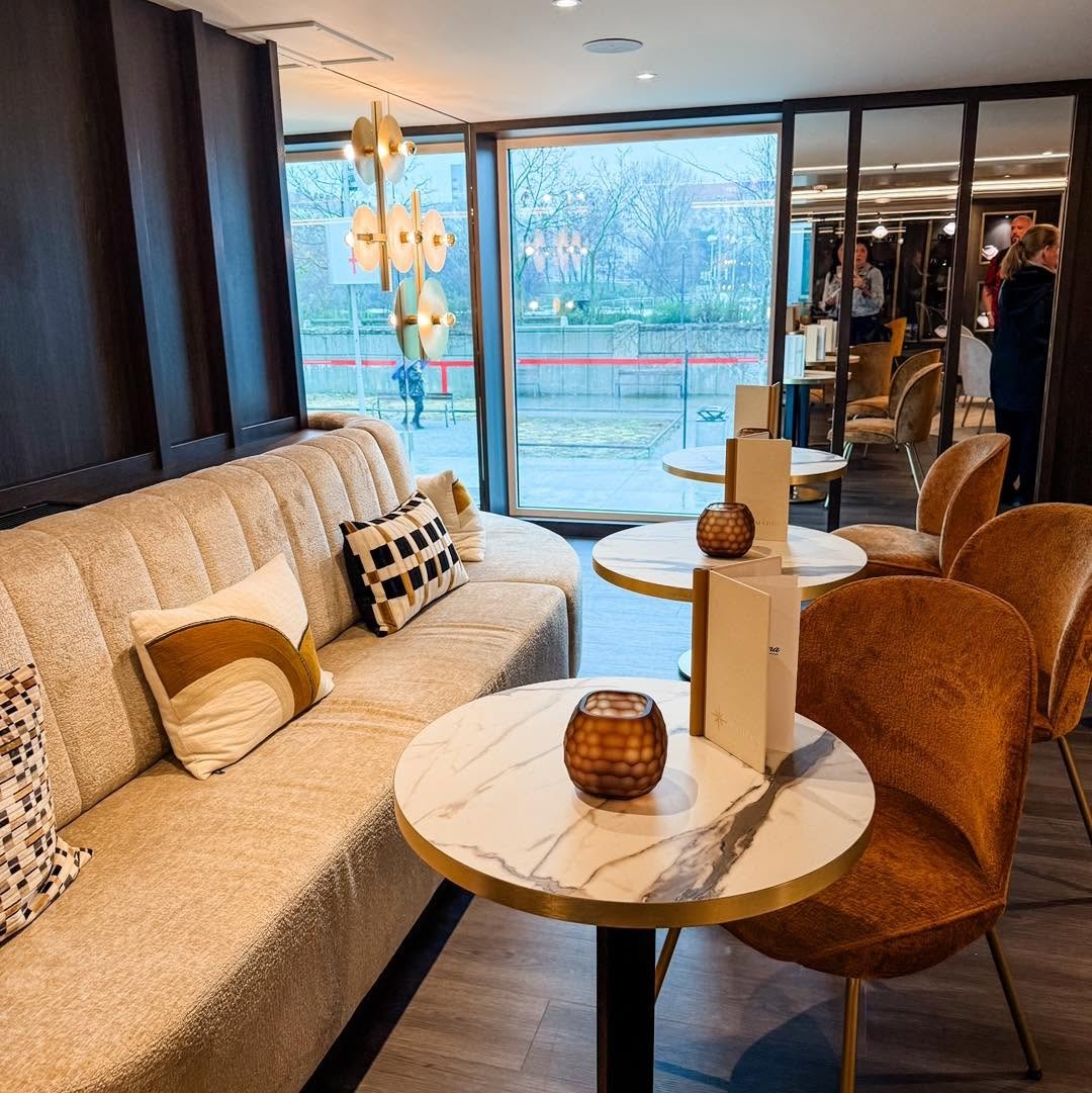 Café Vienna intimate corner lounge with marble table and river views aboard Amadeus Nova