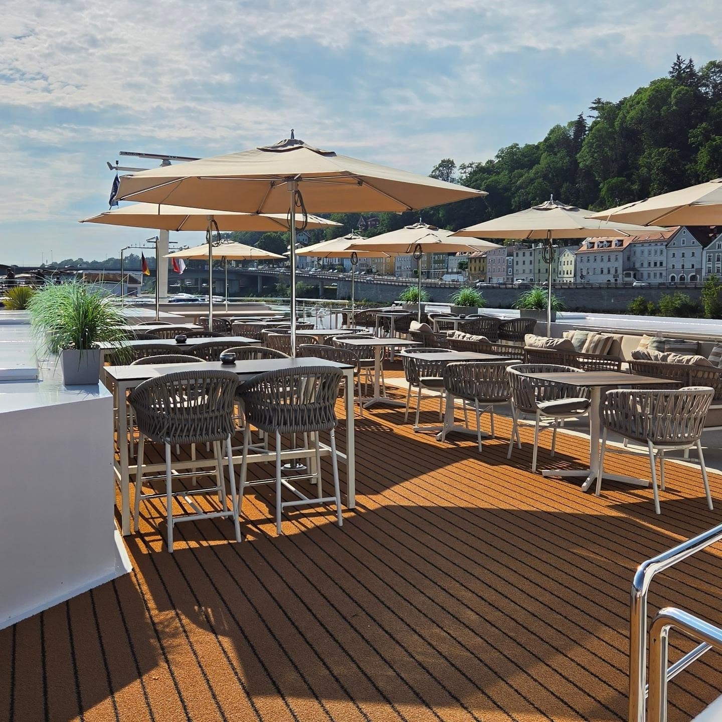 Sun Deck alfresco dining terrace with shaded teak tables and woven chairs aboard Amadeus Nova