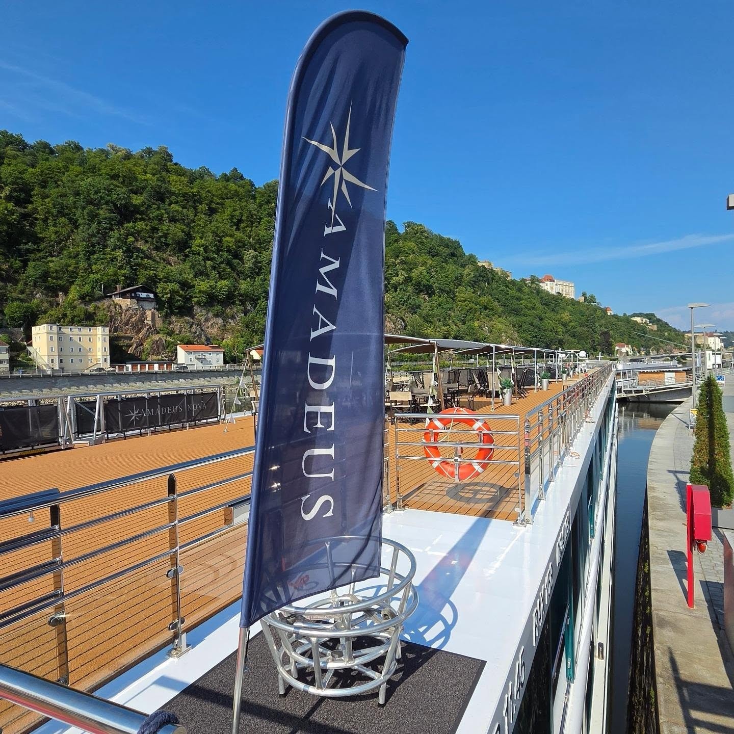 Amadeus River Cruises flag flying proudly on the Sun Deck railing overlooking the river