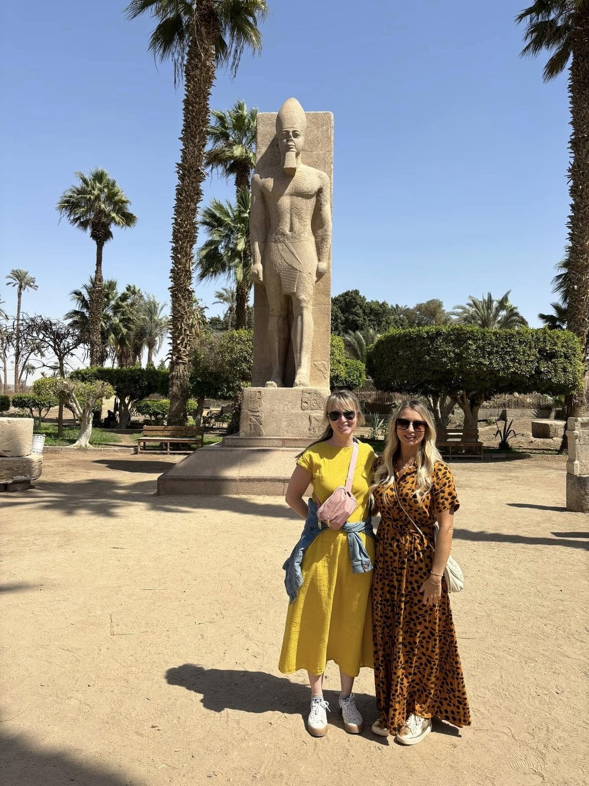 Amanda and her sister Courtney in front of a towering statue at the open-air museum of Memphis