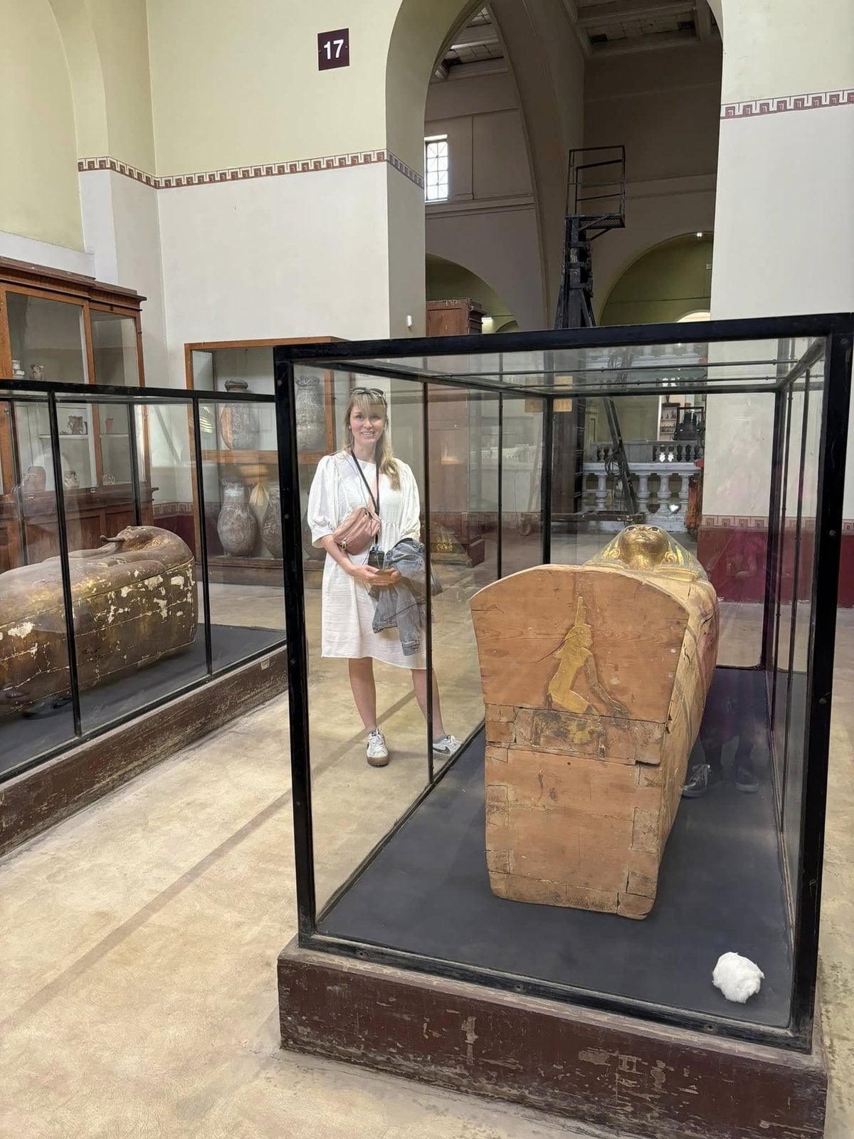 Amanda Burch examining an ancient painted wooden coffin inside the Egyptian Museum