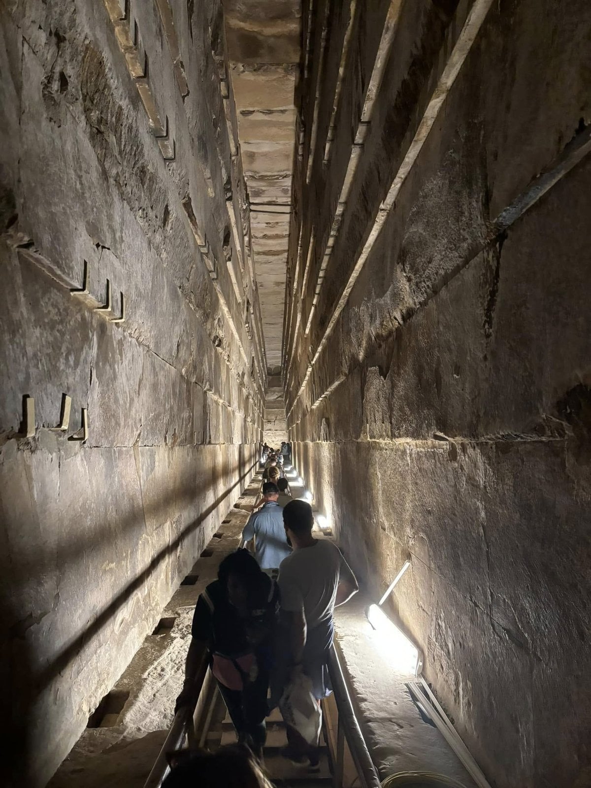 Climbing the narrow stone Grand Gallery shaft inside a Pyramid in Egypt