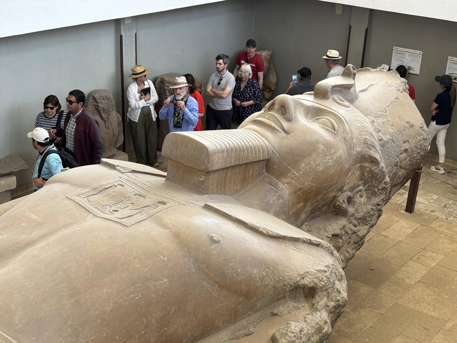Our guided tour group admiring the intricate carvings on the colossal statue of Ramesses II at Memphis