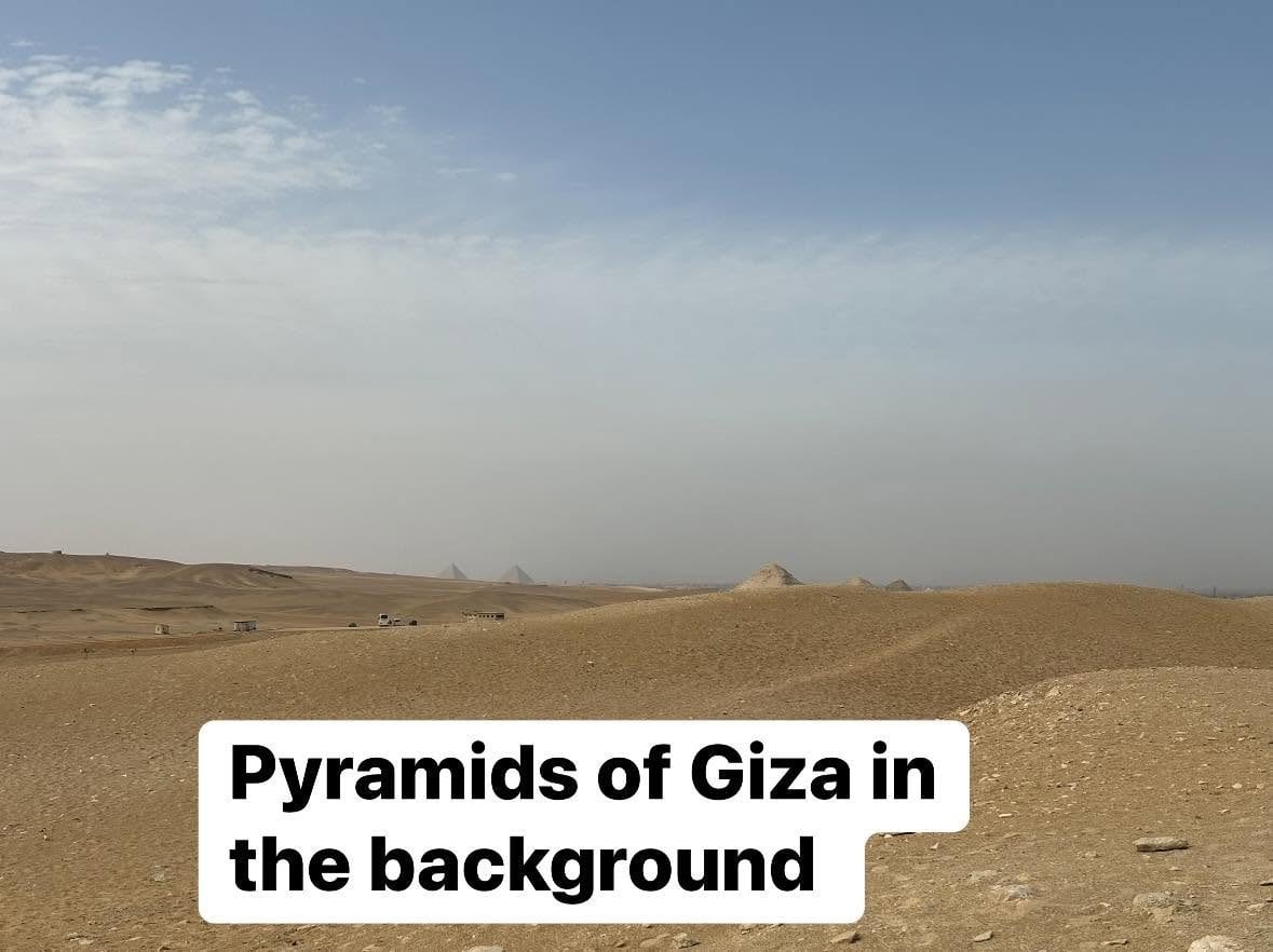 Looking across the desert expanse toward the Pyramids of Giza on the distant horizon