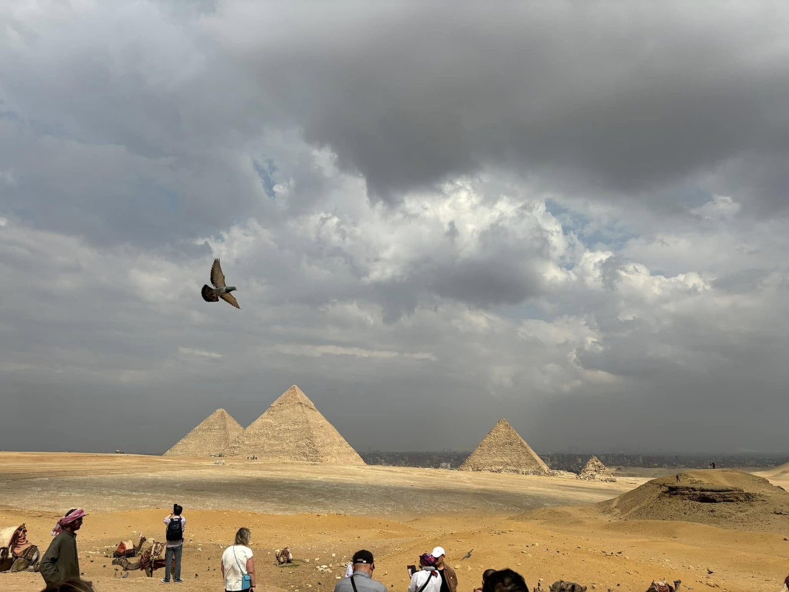 The three Great Pyramids of Giza standing tall beneath dramatic desert skies