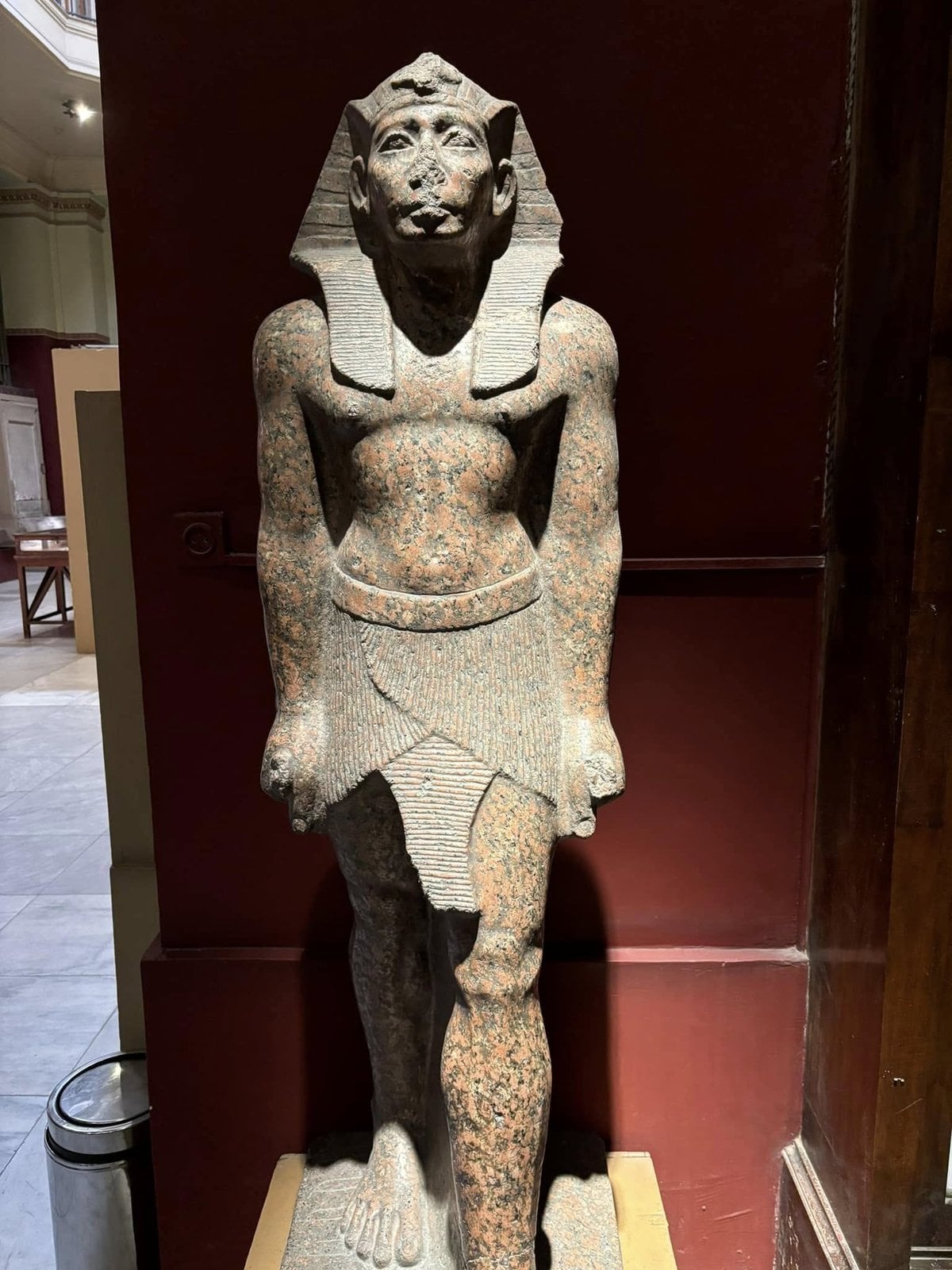 Striding Pharaoh statue with one leg in front of the other inside the Egyptian Museum in Cairo