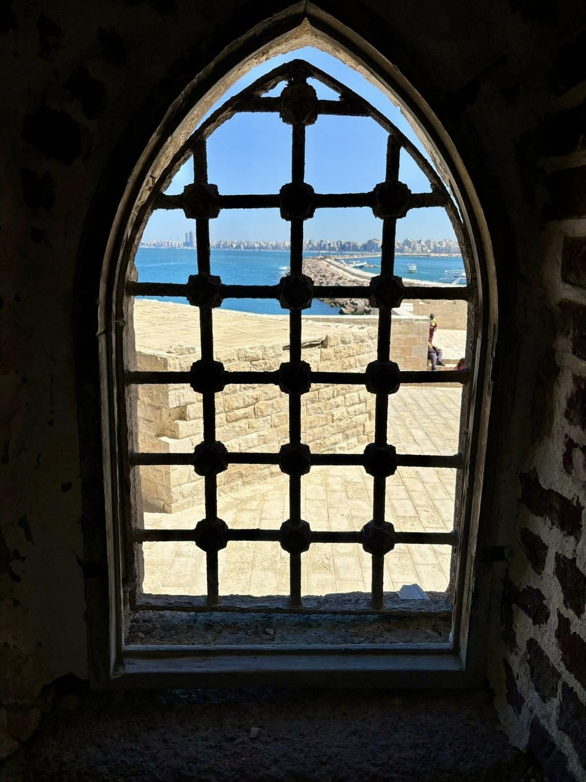 Looking out over the Mediterranean Sea through an arched fortress window inside Alexandria's Qaitbay Citadel