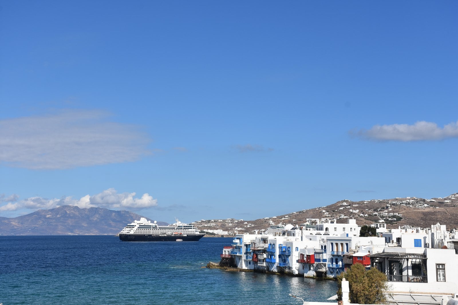 Azamara Onward anchored off the whitewashed coast of Mykonos island in the Aegean Sea