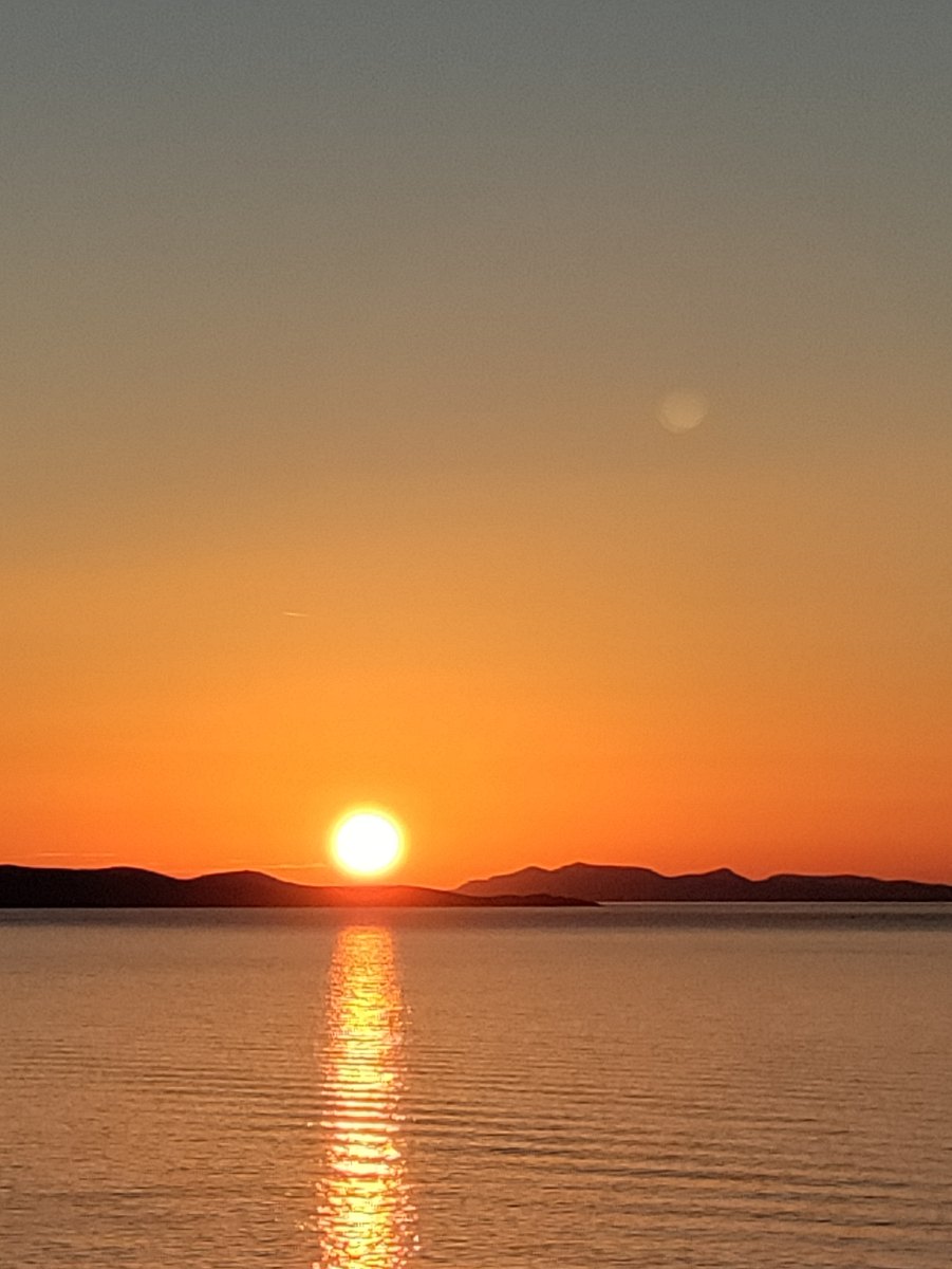 Golden sunset glowing over the calm Aegean Sea from the deck of Azamara Onward