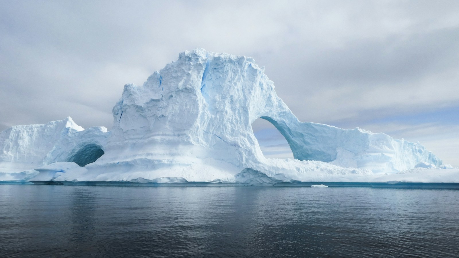 Sculpted four-story blue iceberg natural arch off Portal Point in Antarctica