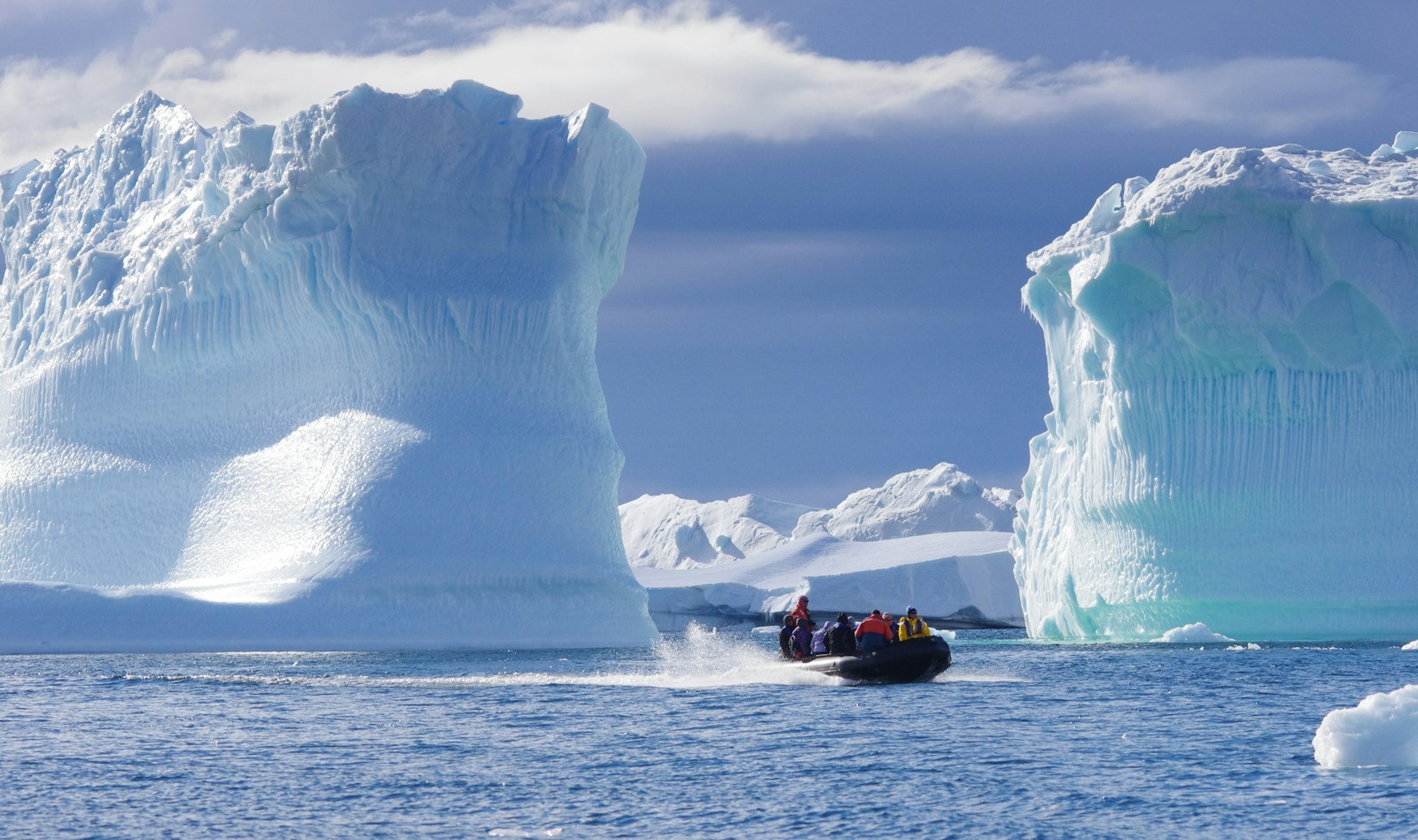 Silversea expedition Zodiac cruising past towering sapphire icebergs in Antarctica