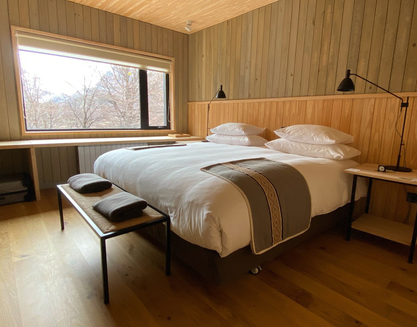 Minimalist luxury bedroom at Explora El Chalten featuring expansive mountain views