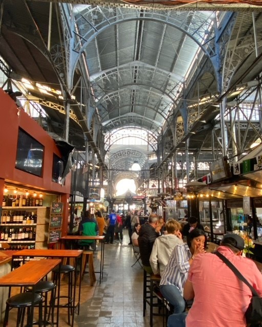 Interior ironwork structure and bustling food stalls of Mercado de San Telmo