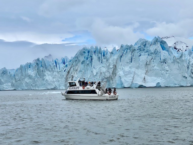 Safari catamaran cruising alongside the massive ice walls of Perito Moreno Glacier