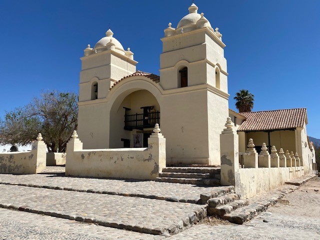 White adobe colonial architecture and historic church in Molinos, Salta