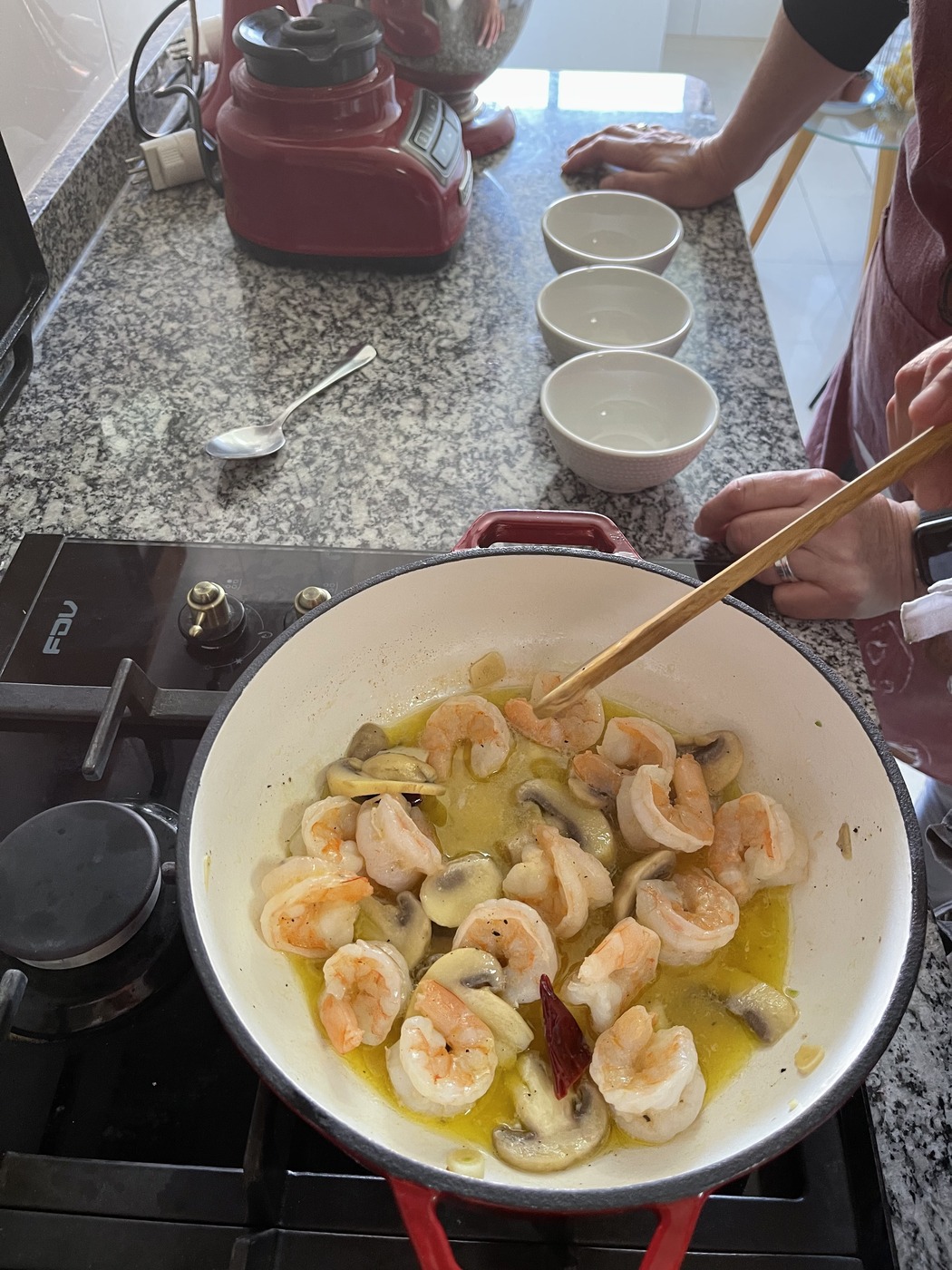 Sizzling shrimp and mushrooms cooking in cast iron skillet