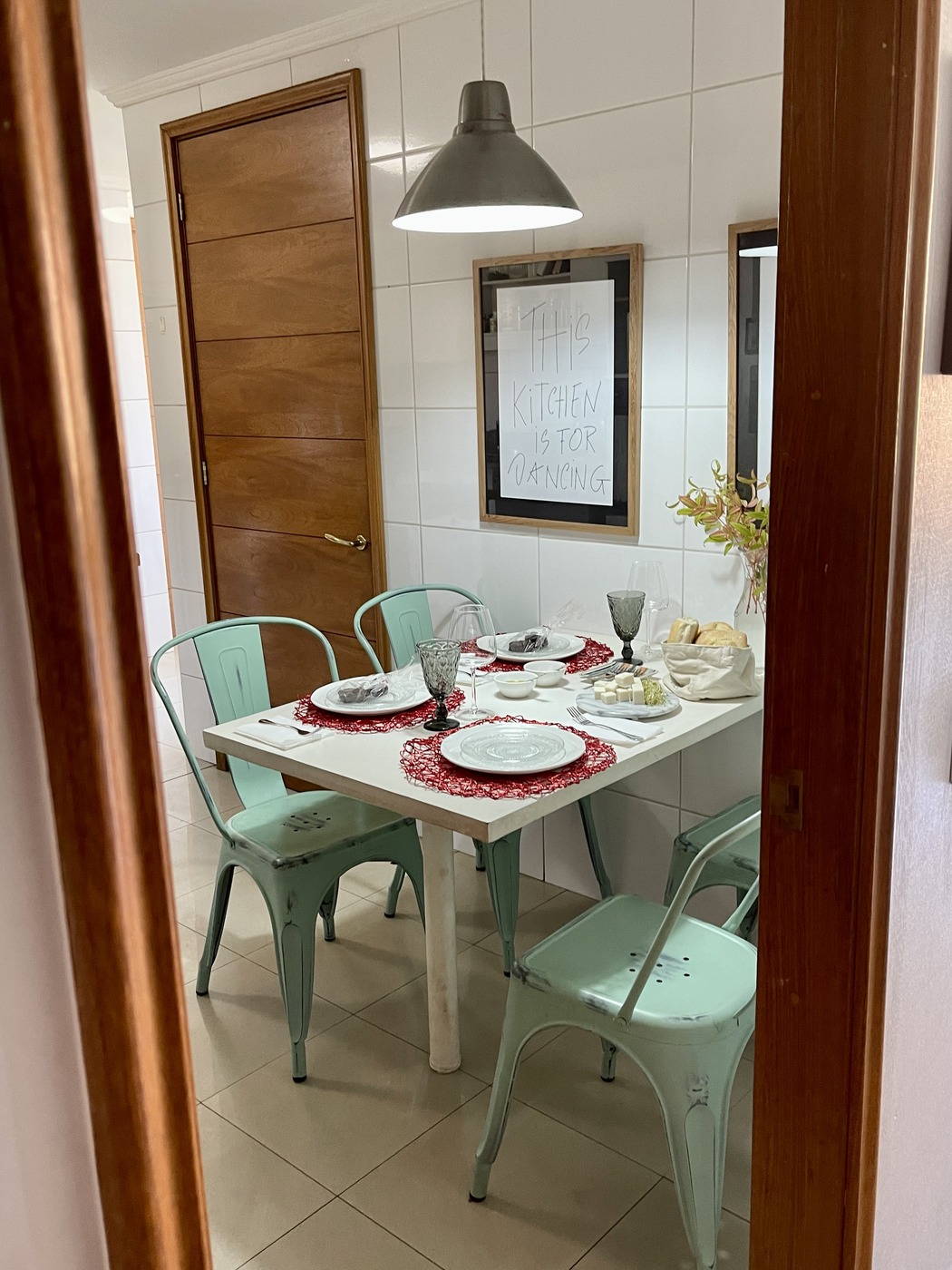 Intimate dining table in chef's home kitchen with This Kitchen is for Dancing sign