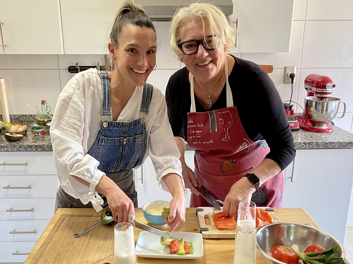 Heidi Podjavorsek and private chef in aprons preparing fresh trout and avocado appetizers