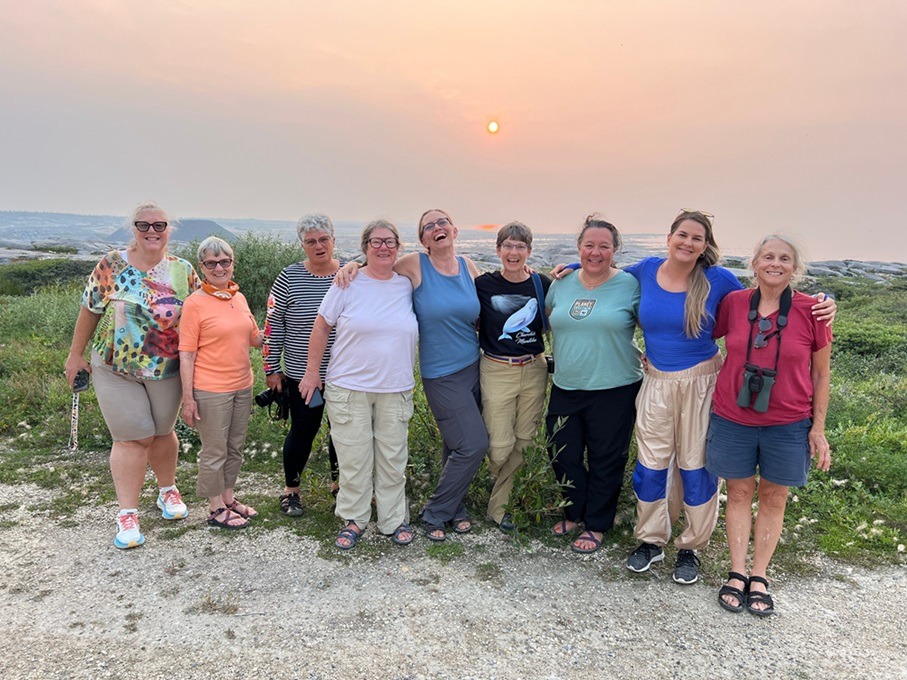 Amanda Merz and the Natural Habitat Adventures Women in the Wild expedition group smiling together at sunset overlooking Hudson Bay