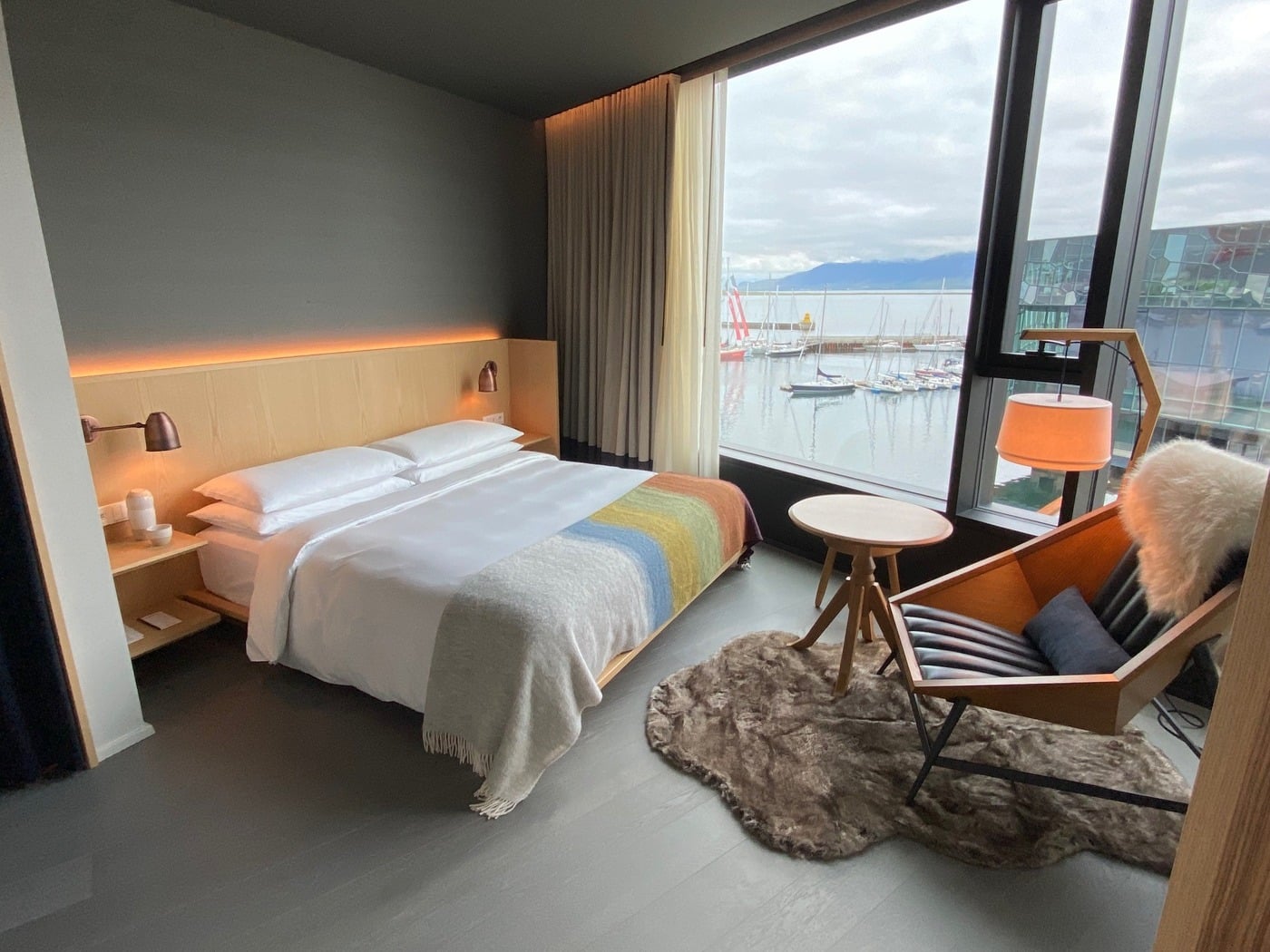 Spacious luxury suite interior at The Reykjavik EDITION featuring floor-to-ceiling windows and contemporary Icelandic timber design
