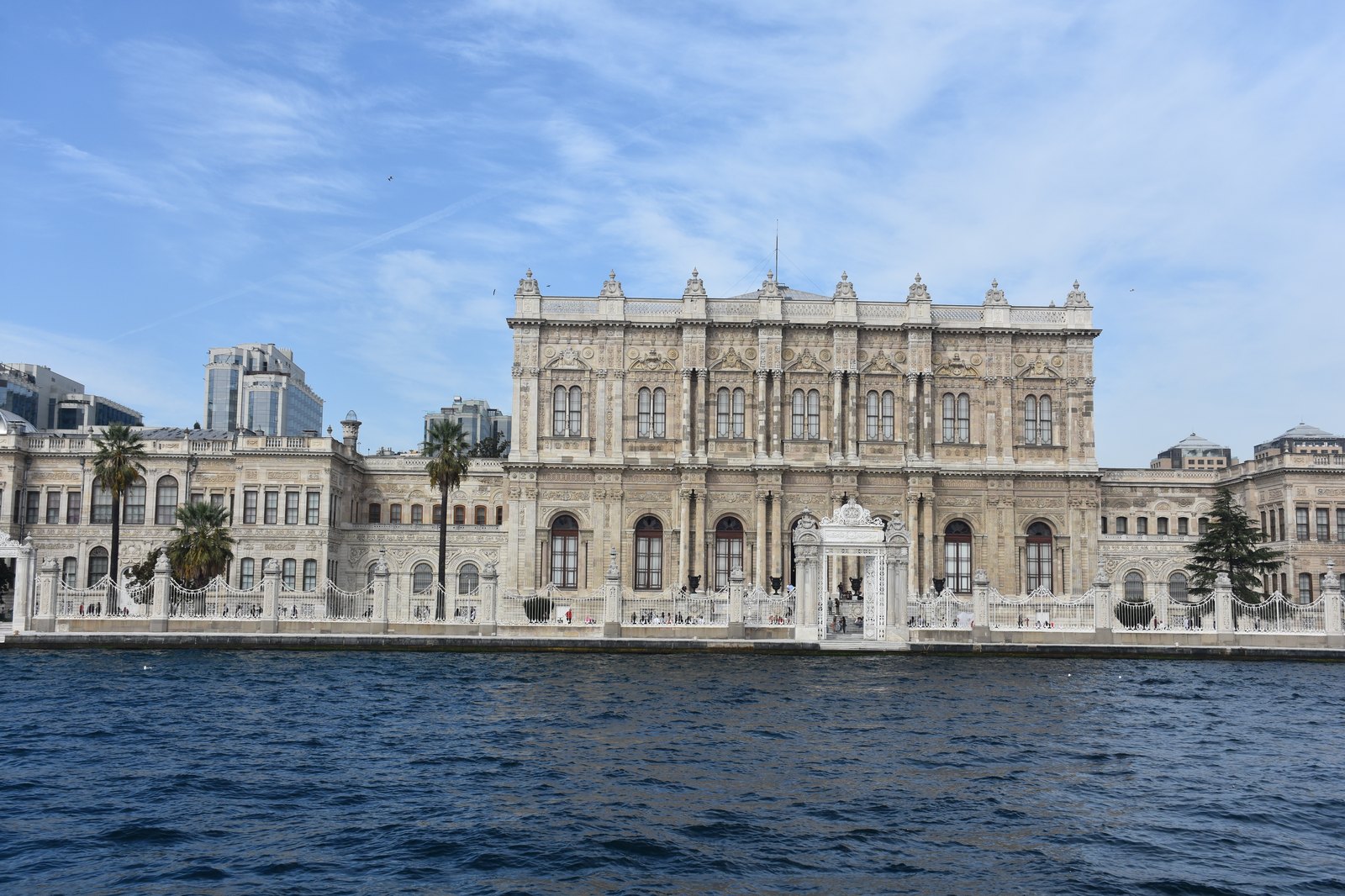 The monumental white marble facade of Dolmabahce Palace viewed from the water on a Bosphorus cruise