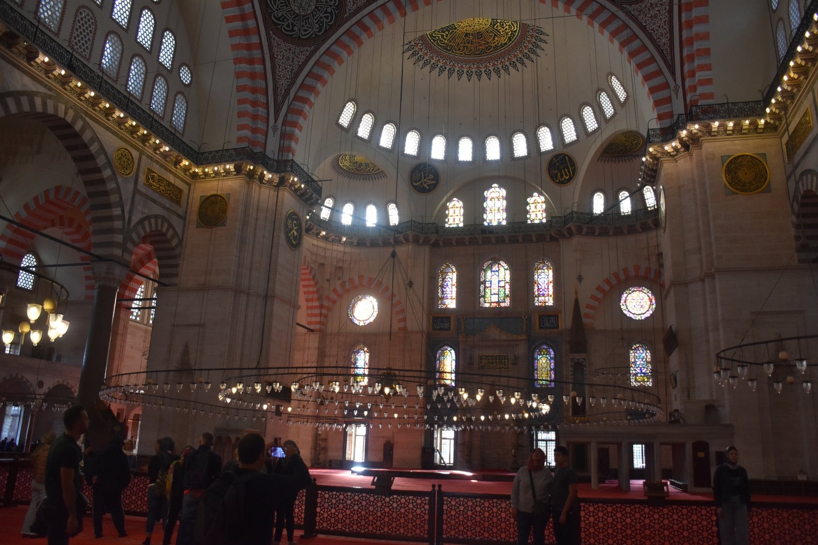Interior view of the monumental dome and hanging chandeliers inside the Suleymaniye Mosque