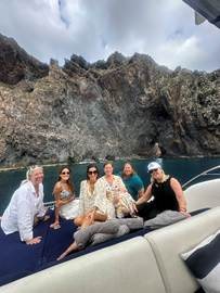 Advisors relaxing on the sun deck of a private chartered yacht cruising beneath Madeira's towering sea cliffs