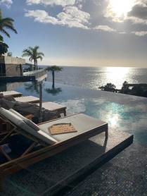 Sunset reflecting on the oceanfront infinity pool and luxury daybeds at Savoy Palace in Madeira