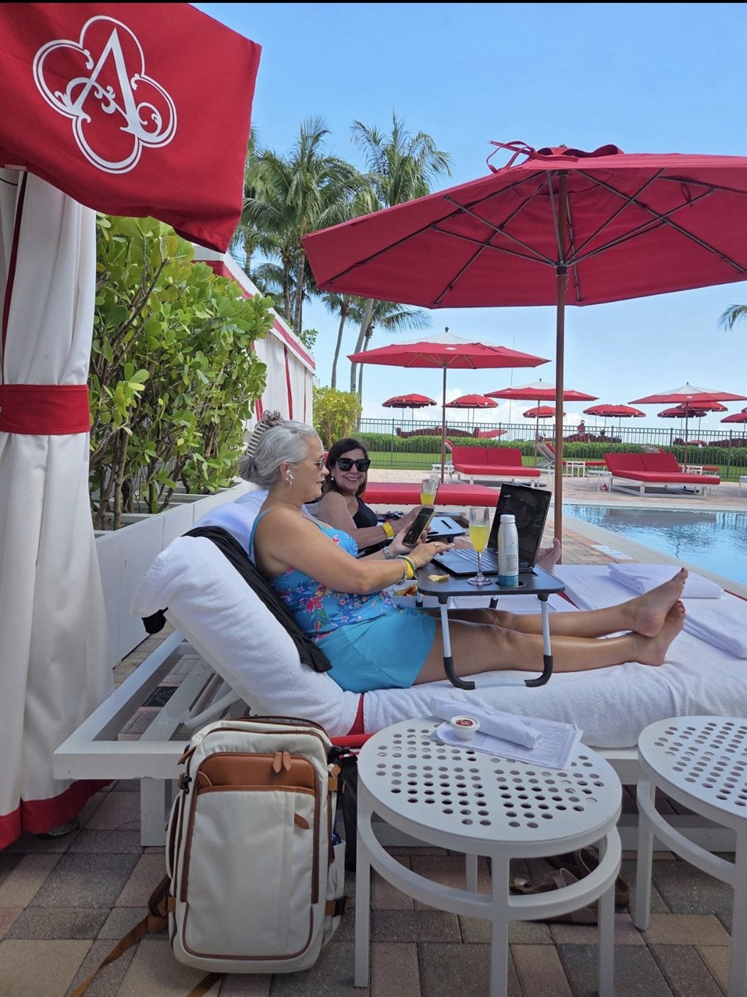 Poolside luxury red cabanas and loungers overlooking the Atlantic Ocean at Acqualina Resort
