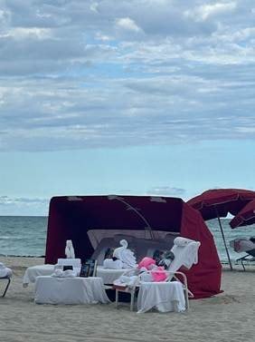 Exclusive beachfront daybed and shaded cabana setup directly on the sand in Miami Beach