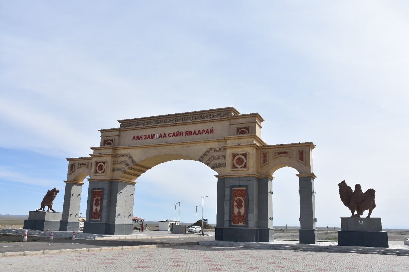 Elaborate decorative gateway arch standing over the desert highway entering a new province