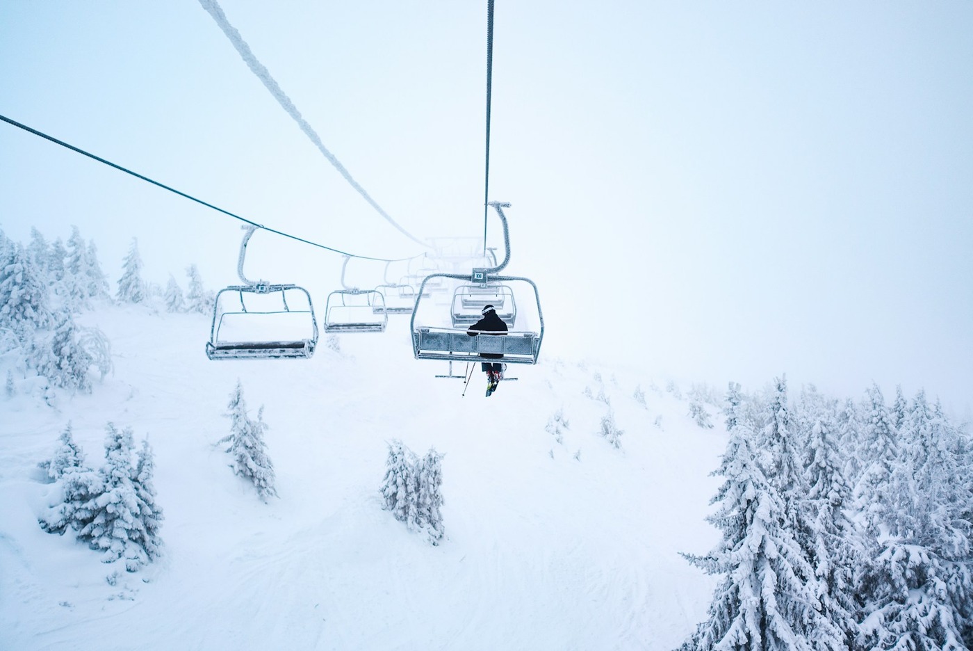 Ski chairlift carrying travelers to the snowy mountain peak of Owl's Head in Quebec