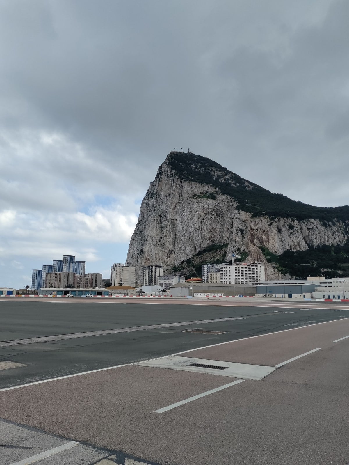 The sheer cliff face of the Rock of Gibraltar seen across the airport runway