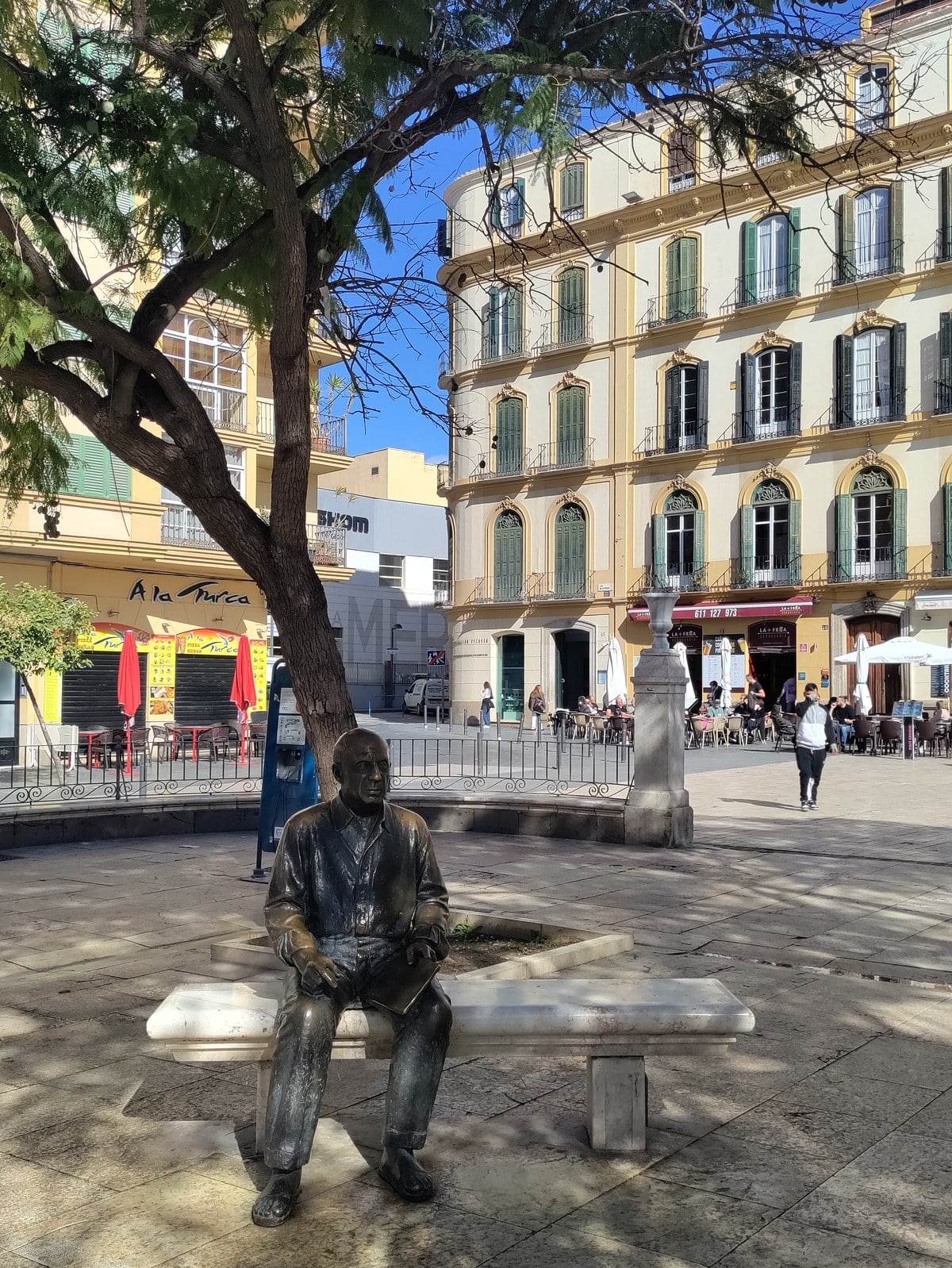 Pablo Picasso bronze statue sitting on bench in Plaza de la Merced Malaga Spain