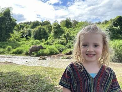 Splashing river water and applying mineral mud with elephants