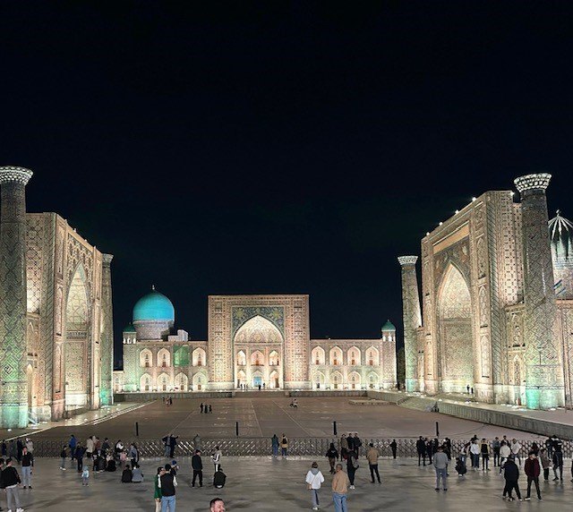 Registan Square illuminated in dazzling golden light after dark