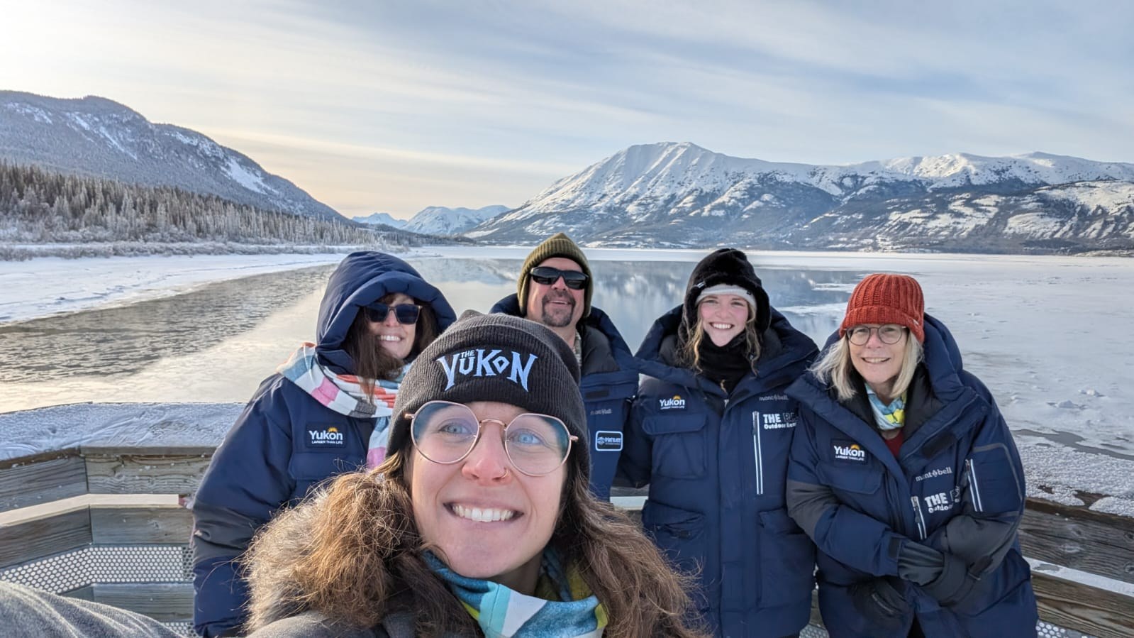 Tourism Yukon Destination Immersion Journey group in front of snowcapped mountains and frozen Tagish Lake