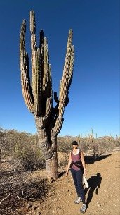Rosie Ferrara standing beside a 30-foot giant Cardon cactus in Baja