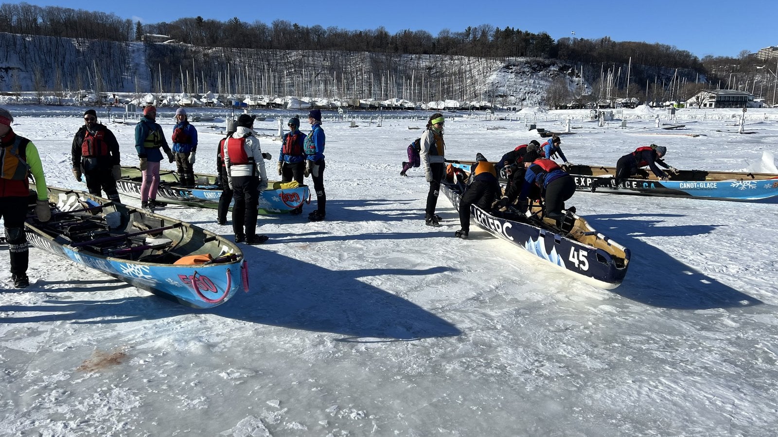 Ice canoeing racers preparing custom canoes on the frozen St. Lawrence River