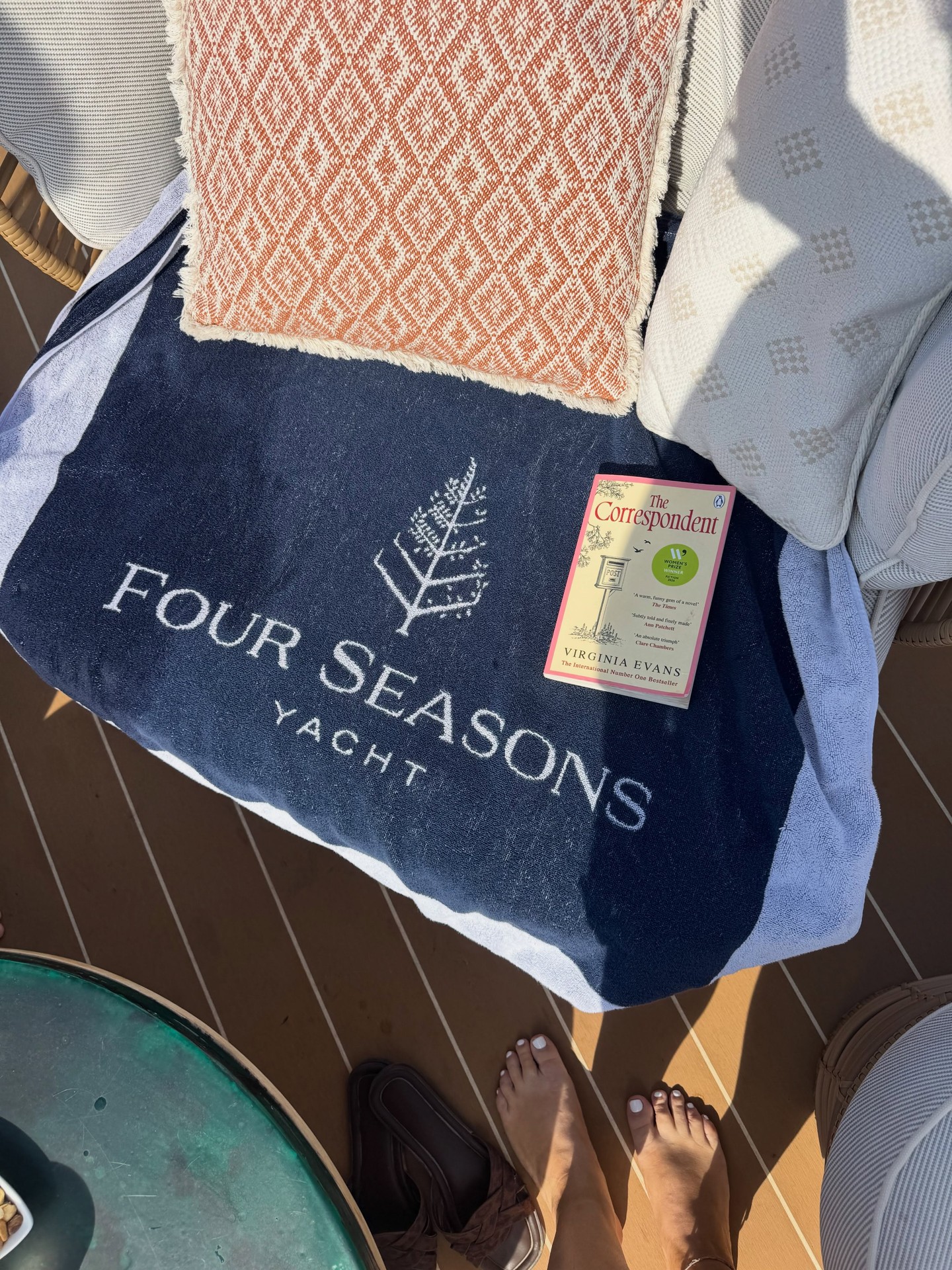 Embroidered Four Seasons Yacht luxury beach tote bag and monogrammed towel on sun lounger