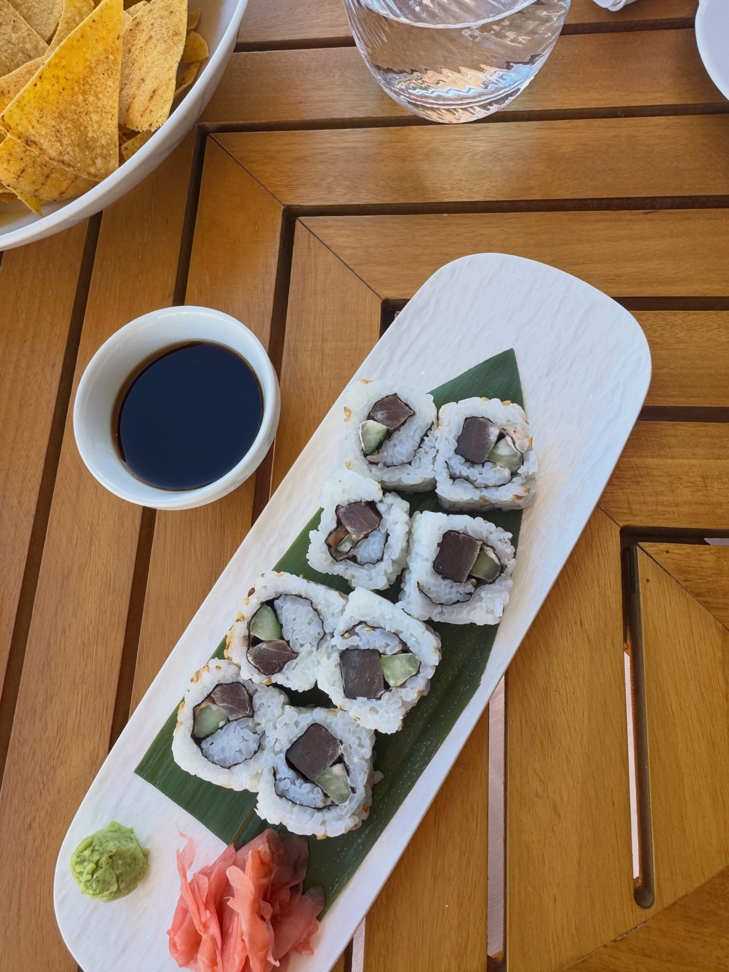 Freshly rolled gourmet sushi platter served on outdoor teak dining table on Four Seasons Yachts