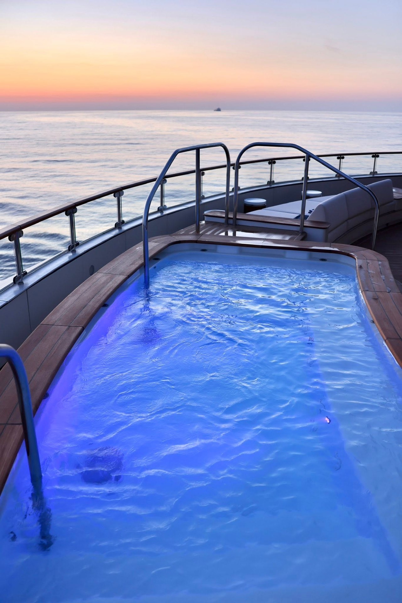 Private terrace whirlpool hot tub glowing at sunset aboard Four Seasons Yachts