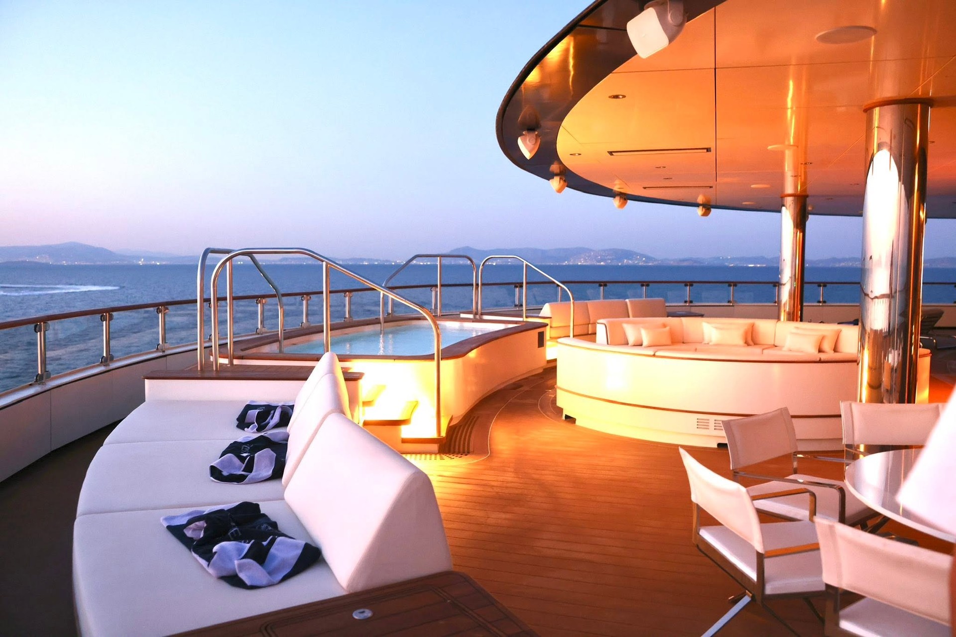 Upper observation deck sunset lounge with circular daybeds on Four Seasons Yachts