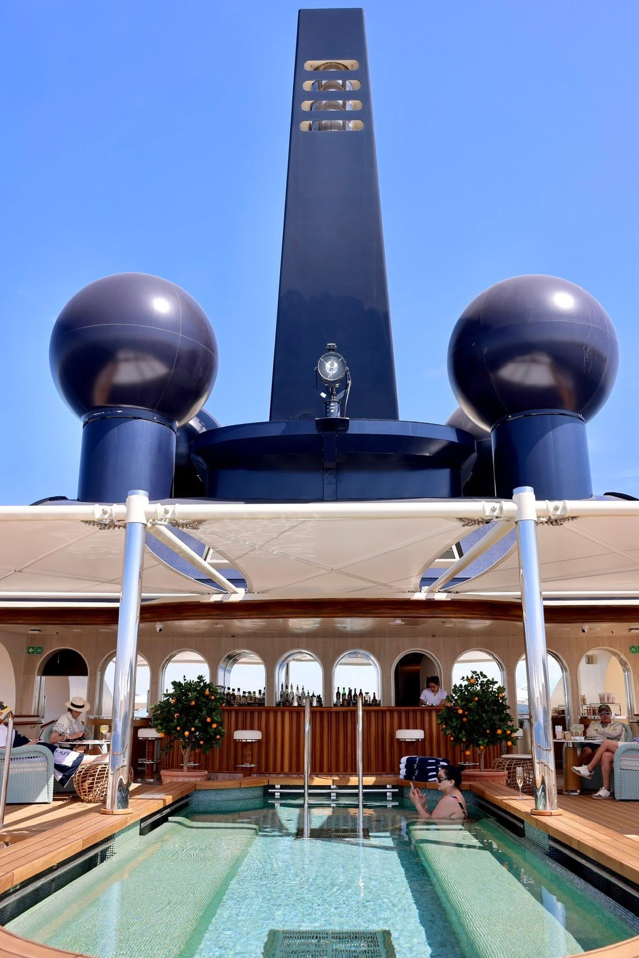 Iconic glass funnel superstructure rising above the pool deck on Four Seasons Yachts