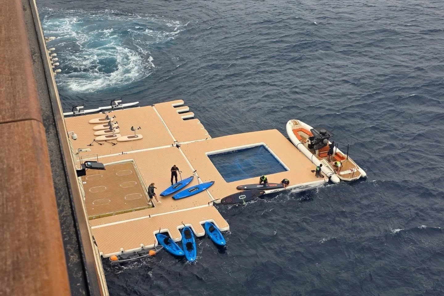 Sea-level transverse marina water sports platform with paddleboards and tender on Four Seasons Yachts