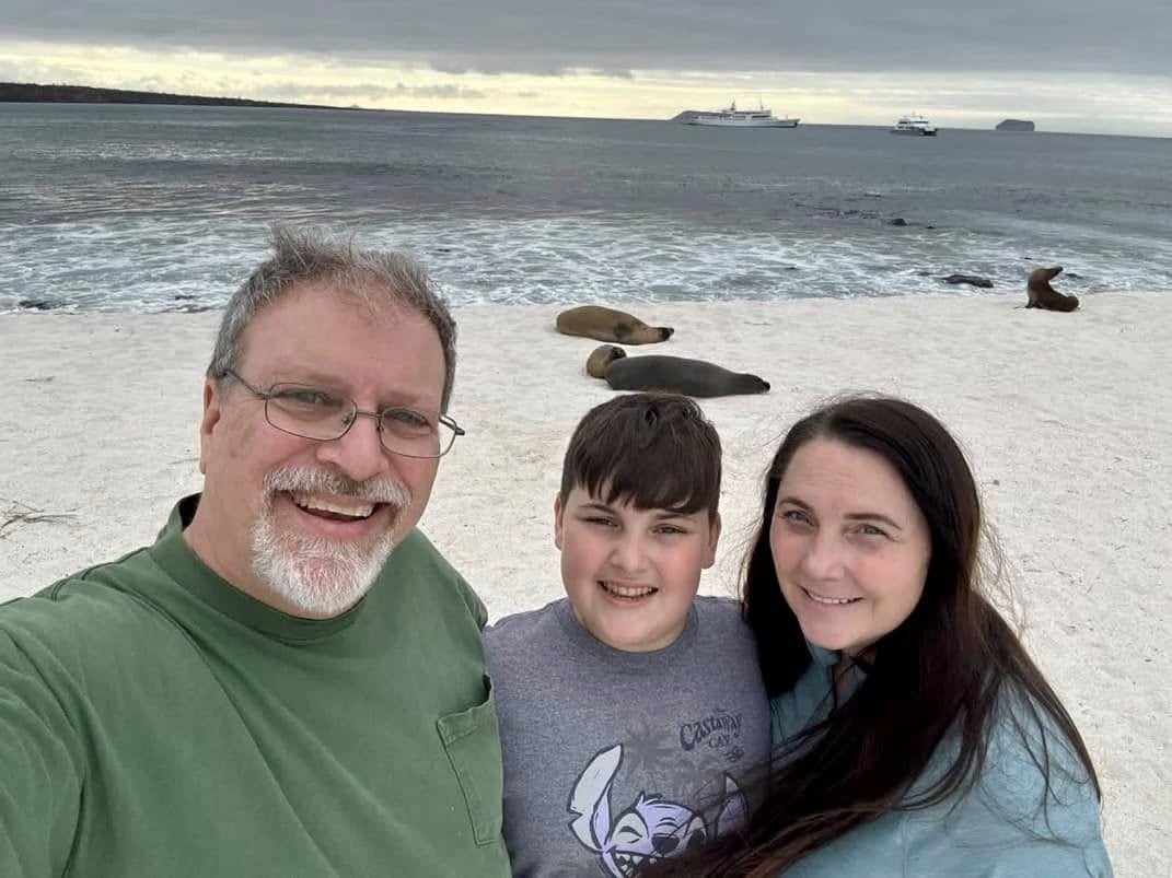 The Herring family sharing the white sand beach with curious Galapagos sea lions