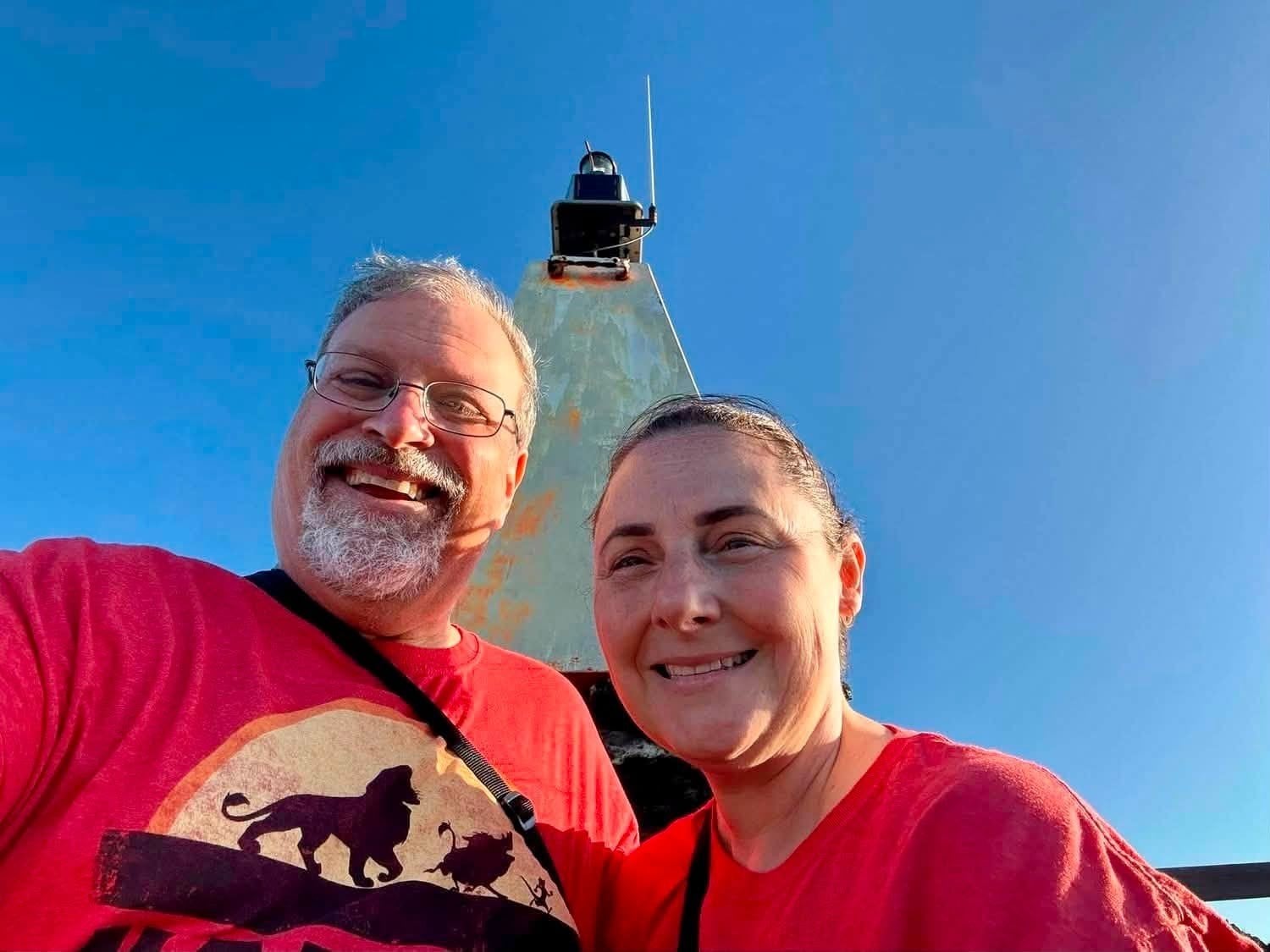 Johnnie Herring and her husband smiling at the lighthouse summit of Bartolome Island