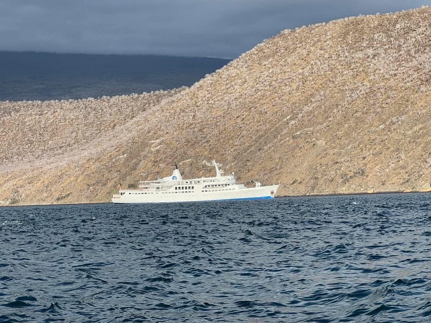Our expedition vessel, the MV Galapagos Legend, anchored beneath towering volcanic cliffs