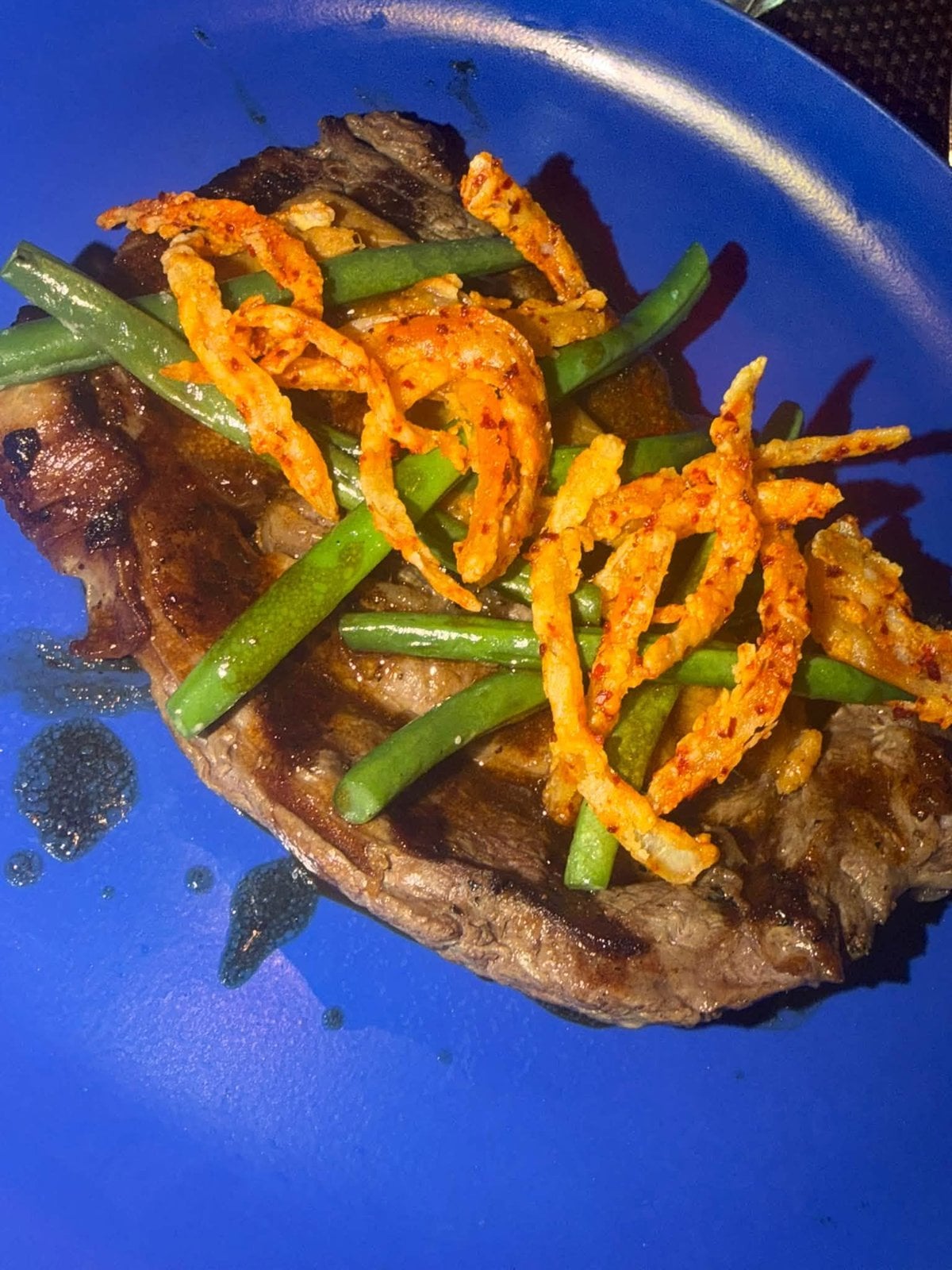 Seared steak with green beans and crispy shoestring fries at Virgin Voyages specialty dining